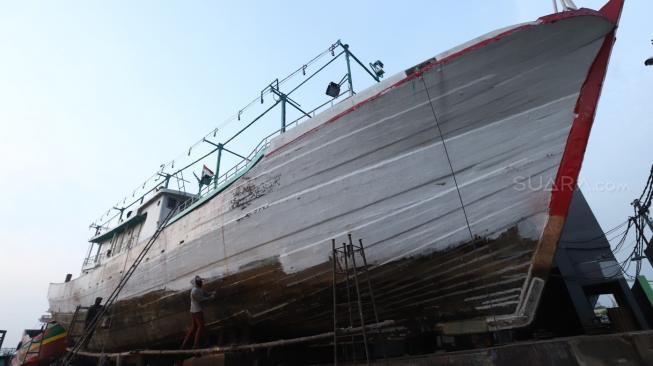 Sejumlah tukang menyelesaikan pekerjaan kapal nelayan di Galangan Kapal Muara Angke, Jakarta, Selasa (6/11). [Suara.com/Muhaimin A Untung] 