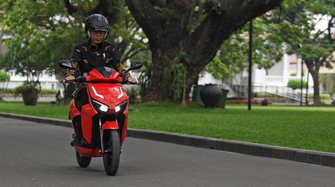 Presiden Joko Widodo menjajal motor listrik buatan dalam negeri Gesits seusai melakukan audiensi dengan pihak-pihak yang terlibat proses produksi di halaman tengah Istana Kepresidenan, Jakarta, Rabu (7/11). [ANTARA FOTO/Wahyu Putro]