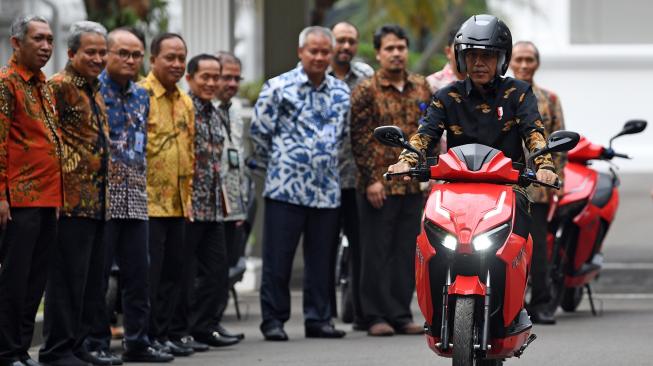 Presiden Joko Widodo menjajal motor listrik buatan dalam negeri Gesits seusai melakukan audiensi dengan pihak-pihak yang terlibat proses produksi di halaman tengah Istana Kepresidenan, Jakarta, Rabu (7/11). [ANTARA FOTO/Wahyu Putro]