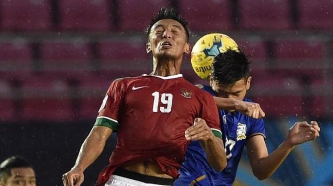 Pemain timnas Indonesian Bayu Pradana (kiri) berebut bola dengan pemain Thailand saat Piala AFF 2016 di Filipina. TED ALJIBE / AFP