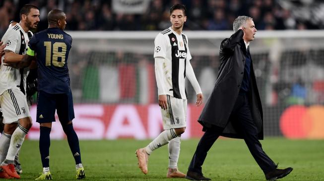 Gelandang Manchester United Ashley Young menahan pemain belakang Juventus Leonardo Bonucci saat Jose Mourinho melakukan selebrasi di akhir pertandingan Group H Liga Champions Juventus melawan Manchester United di Stadion Allianz, Turin, Italia, Kamis (8/11). [AFP/Marco BERTORELLO]