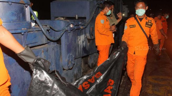 Petugas Basarnas memindahkan kantong jenazah korban pesawat Lion Air PK-LQP dari KN SAR Basarnas di Pelabuhan Tanjung Priok, Jakarta Utara, Kamis (8/11). (Suara.com/Fakhri Hermansyah)