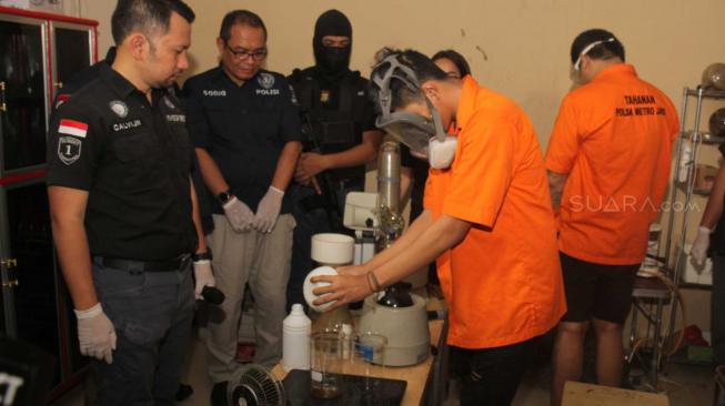 Sejumlah tersangka kasus liquid narkoba saat memperlihatkan proses pembuatan narkoba di perumahan daerah Kelapa Gading, Jakarta Utara, Kamis (8/11). (Suara.com/Fakhri Hermansyah)