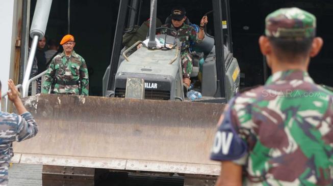 Sejumlah anggota TNI mengeluarkan mesin alat berat dari kapal saat tiba di Pelabuhan Tanjung Priok, Jakarta Utara, Kamis (8/11). (Suara.com/Fakhri Hermansyah)