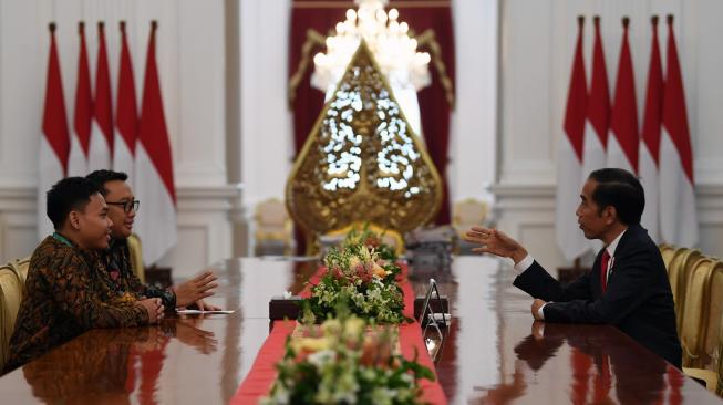 Presiden Joko Widodo (Jokowi) menerima Menpora Imam Nahrawi (tengah) dan lifter Eko Yuli Irawan (kiri) di Istana Merdeka, Jakarta, Kamis (8/11/2018). [Antara/Wahyu Putro A]