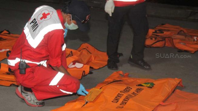 Tim SAR gabungan mengidentifikasi kantong jenazah korban pesawat Lion Air PK-LQP dari KN SAR Basarnas di Pelabuhan Tanjung Priok, Jakarta Utara, Kamis (8/11). (Suara.com/Fakhri Hermansyah)