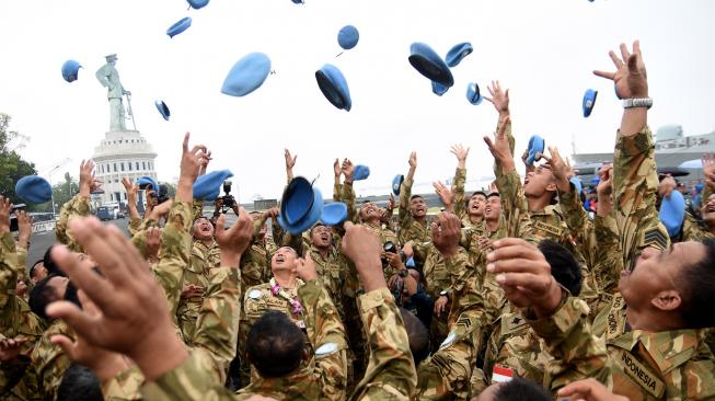 Task Force (MTF) Konga XXVIII.J UNIFIL melempar topi pad ketika tiba di Dermaga Ujung Koarmada II Surabaya, Jawa Timur, Kamis (8/11). [ANTARA FOTO/M Risyal Hidayat]