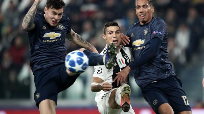 Bek Manchester United Victor Lindelof, Cristiano Ronaldo, dan bek Manchester United, Chris Smalling, memperebutkan bola selama pertandingan Group H Liga Champions Juventus melawan Manchester United di Stadion Allianz, Turin, Italia, Kamis (8/11). [AFP/Isabella BONOTTO]