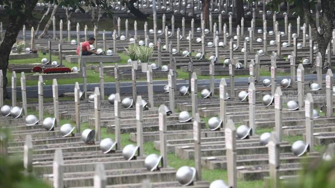 Pekerja membersihkan makam jelang peringatan hari pahlawan di Taman Makam Pahlawan (TMP) Kalibata, Jakarta, Jumat (9/11). [Suara.com/Muhaimin A Untung] 