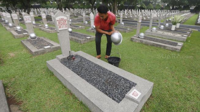 Pekerja membersihkan makam jelang peringatan hari pahlawan di Taman Makam Pahlawan (TMP) Kalibata, Jakarta, Jumat (9/11). [Suara.com/Muhaimin A Untung] 