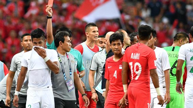 Pemain timnas Indonesia Putu Gede Juni Antara (kedua kiri) meninggalkan lapangan setelah terkena kartu merah saat melawan timnas Singapura dalam penyisihan grub B Piala AFF 2018 di Stadion Nasional Singapura, Jumat (9/11/2018). Indonesia kalah 0-1 dalam pertandingan perdana tersebut. ANTARA FOTO/Sigid Kurniawan