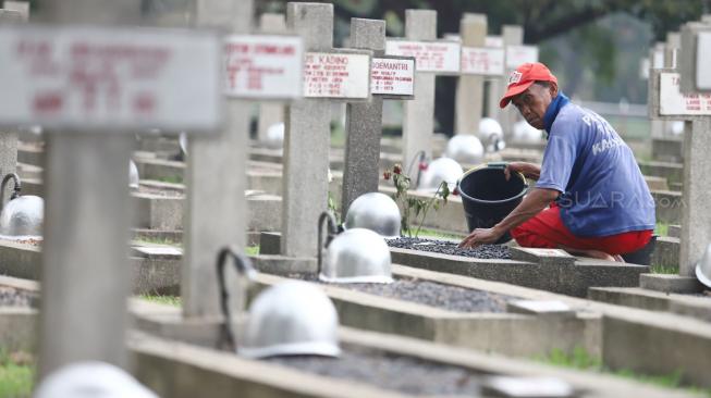 Pekerja membersihkan makam jelang peringatan hari pahlawan di Taman Makam Pahlawan (TMP) Kalibata, Jakarta, Jumat (9/11). [Suara.com/Muhaimin A Untung] 