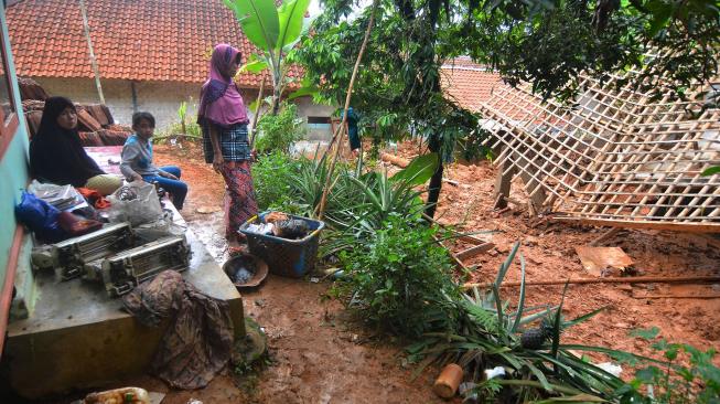 Warga menyaksikan rumah yang tertimbun material tanah longsor di Desa Bojongsari, Kabupaten Tasikmalaya, Jawa Barat, Kamis (8/11). [ANTARA FOTO/Adeng Bustomi]