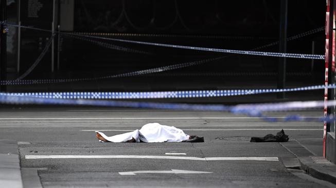 Sebuah mayat terlihat ditutupi selembar kain putih di tempat kejadian insiden penusukan di Melbourne, Australia, Jumat (9/11).[AFP/William West]