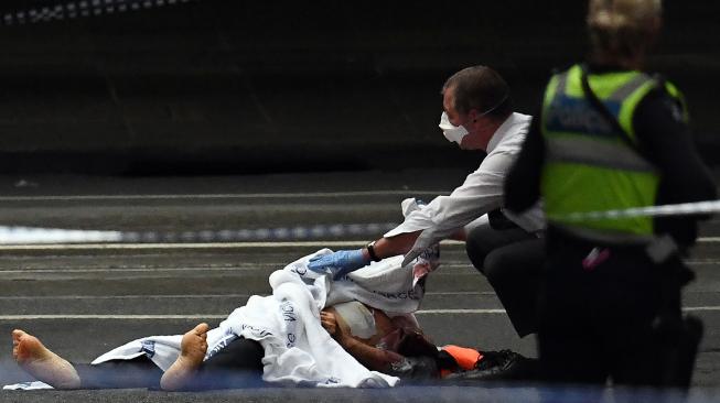 Polisi memeriksa mayat di TKP insiden penikaman di Melbourne, Australia, Jumat (9/11). [AFP/William West]