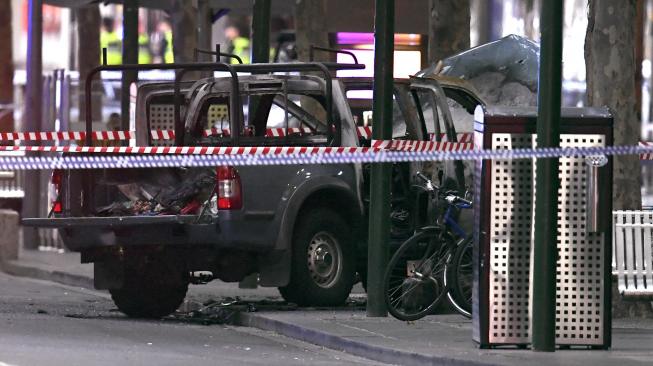 Sebuah kendaraan yang terbakar di TKP insiden penusukan di Melbourne, Australia, Jumat (9/11). [AFP/William West]