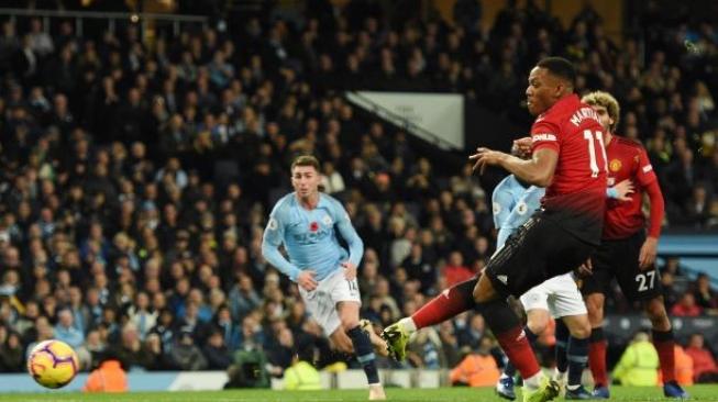 Penyerang Manchester United, Anthony Martial melakukan eksekusi penalti ke gawang Manchester City di laga derby Liga Primer Inggris, Minggu (11/11/2018). Dalam laga itu Manchester City menang 3-1 atas Manchester United. [OLI SCARFF / AFP]