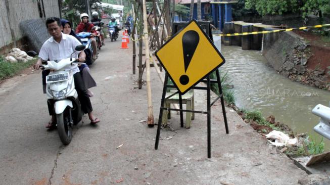 Suasana tanah longsor di Jalan Tiu yang berdekatan dengan pintu air sunter hulu daerah Setu Cipayung, Jakarta Timur, Senin (12/11). (Suara.com/Fakhri Hermansyah)