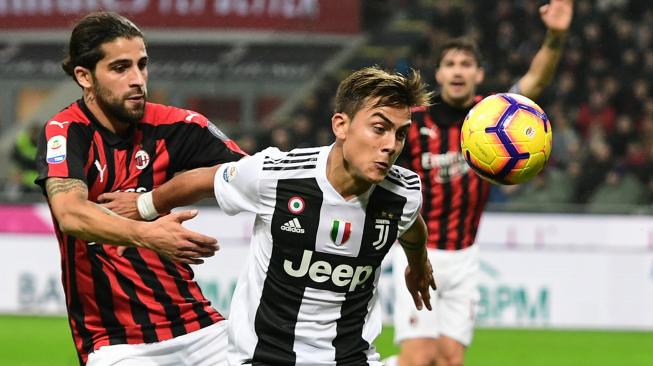 Pemain depan Juventus Paulo Dybala menahan bek AC Milan Ricardo Rodriguez selama pertandingan sepak bola Serie A Italia AC Milan melawan Juventus di Stadion San Siro, Milan, Italia, Senin (12/11). [AFP/Miguel MEDINA]