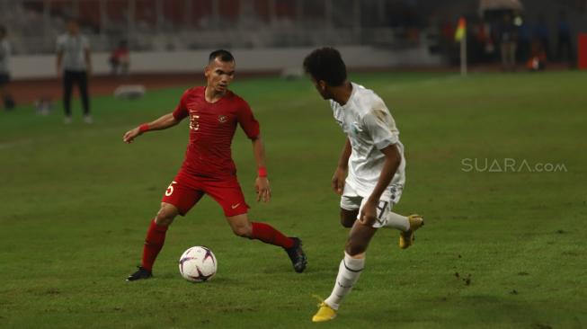 Pesepak bola Indonesia Riko Simanjuntak berusaha melewati pesebak bola Timor Leste Jose Guterress saat laga lanjutan Piala AFF 2018 di Stadion Utama Gelora Bung Karno, Jakarta, Selasa (13/11). [Suara.com/Muhaimin A Untung]