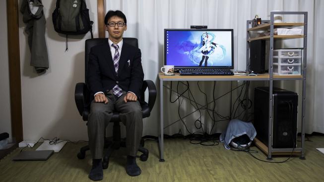 Akihiko Kondo berpose di sebelah layar komputer yang menampilkan gambar aktris virtual, Hatsune Miku di Tokyo, Jepang, Sabtu (10/11). (AFP/Behrouz MEHRI)