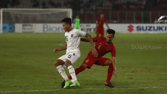 Pesepak bola Indonesia Muhammad Hargianto berebut bola dengan pesebak bola Timor Leste saat laga lanjutan Piala AFF 2018 di Stadion Utama Gelora Bung Karno, Jakarta, Selasa (13/11). [Suara.com/Muhaimin A Untung]