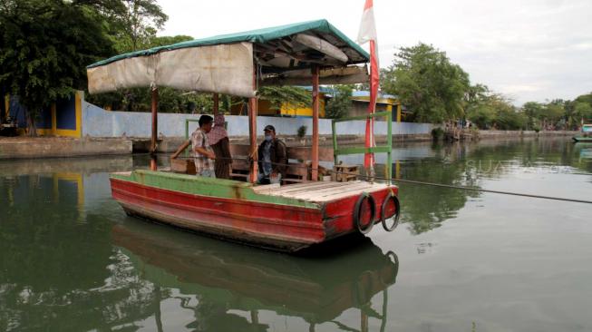 Sejumlah perahu eretan melayani warga yang ingin menyeberangi Kali Sunter di Rawa Badak, Jakarta Utara, Rabu (14/11).  (Suara.com/Fakhri Hermansyah)