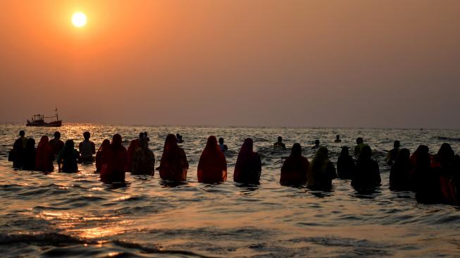 Umat ​​Hindu India berdoa di laut selama festival Chhath Puja di Mumbai, India, Selasa (13/11). [AFP/ PUNIT PARANJPE]