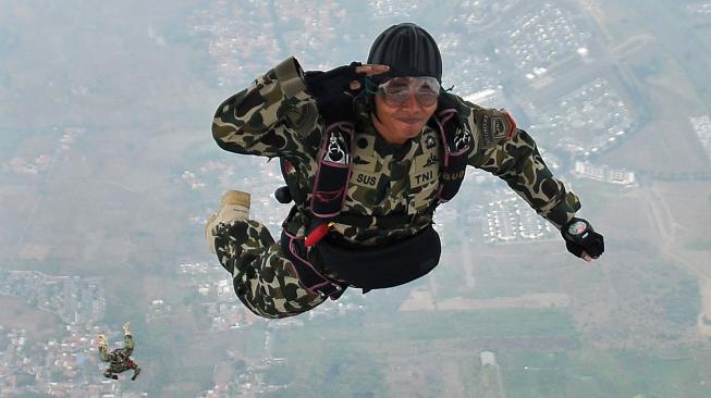 Seorang prajurit Korps Marinir TNI AL memberi hormat ketika melompat mengikuti terjun bebas (free fall) pesawat udara Cassa U-6212 Skuadron Udara 600 Wing Udara-1 Puspenerbal diatas Bhumi Marinir Karangpilang Surabaya, Jawa Timur, Kamis (15/11). [ANTARA FOTO/M Risyal Hidayat]