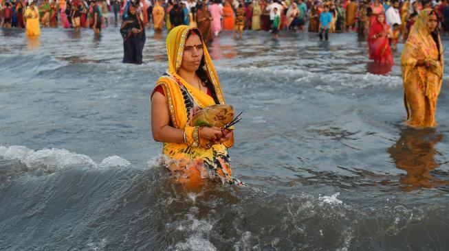 Umat ​​Hindu India berdoa di laut selama festival Chhath Puja di Mumbai, India, Selasa (13/11). [AFP/ PUNIT PARANJPE]