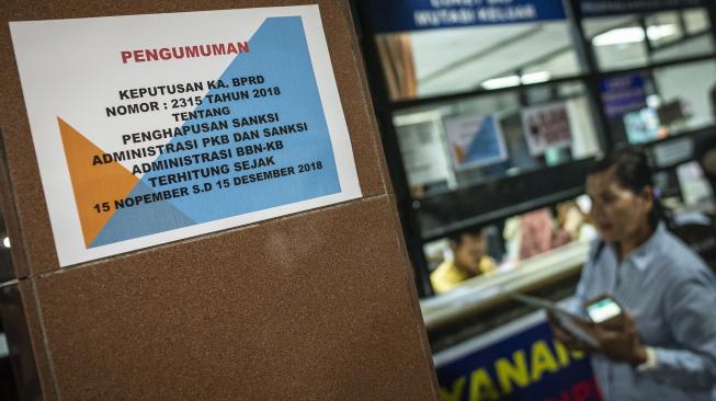 Warga menyelesaikan pembayaran pajak kendaraan bermotor di Kantor Samsat Polda Metro Jaya, Jakarta, Jumat (16/11).  [ANTARA FOTO/Aprillio Akbar]