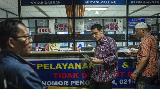 Warga menyelesaikan pembayaran pajak kendaraan bermotor di Kantor Samsat Polda Metro Jaya, Jakarta, Jumat (16/11).  [ANTARA FOTO/Aprillio Akbar]