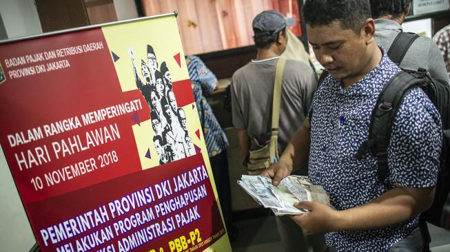 Warga memeriksa dokumen saat melakukan pembayaran pajak kendaraan bermotor di Kantor Samsat Polda Metro Jaya, Jakarta, Jumat (16/11). [ANTARA FOTO/Aprillio Akbar]