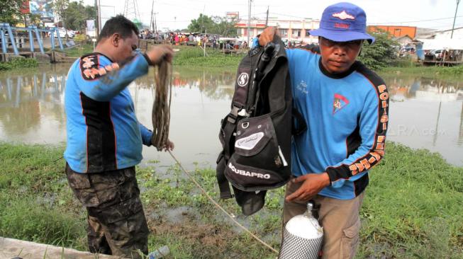 Pencarian barang bukti linggis yang digunakan tersangka kasus pembunuhan Haris Simamora di Aliran Kalimalang, Cikarang, Jawa Barat, Sabtu (17/11).(Suara.com/Fakhri Hermansyah)