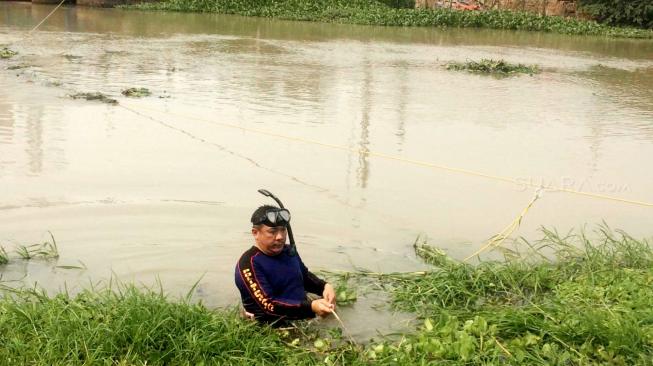 Pencarian barang bukti linggis yang digunakan tersangka kasus pembunuhan Haris Simamora di Aliran Kalimalang, Cikarang, Jawa Barat, Sabtu (17/11). (Suara.com/Fakhri Hermansyah)