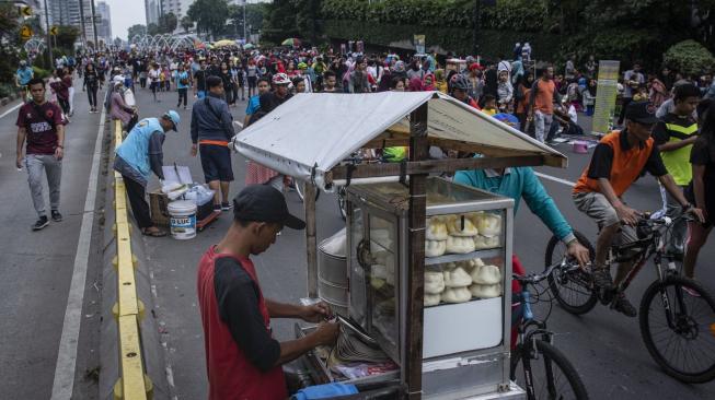 Pedagang kaki lima (PKL) berjualan di jalan saat pelaksanaan Hari Bebas Kendaraan Bermotor di kawasan Bundaran HI, Jakarta, Minggu (18/11). ANTARA FOTO/Aprillio Akbar