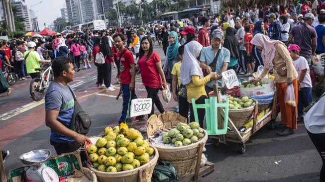 Pedagang kaki lima (PKL) berjualan di jalan saat pelaksanaan Hari Bebas Kendaraan Bermotor di kawasan Bundaran HI, Jakarta, Minggu (18/11). ANTARA FOTO/Aprillio Akbar