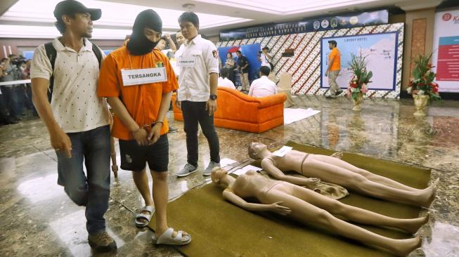 Tersangka HS melakukan reka ulang kejadian saat Prarekonstruksi kasus pembunuhan satu keluarga Diperum Nainggolan alias Gaban di Polda Metro Jaya, Jakarta, Senin (19/11). [Suara.com/Muhaimin A Untung]