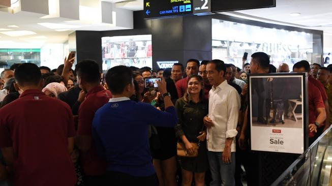 Presiden Joko Widodo (kanan) berfoto dengan masyarakat saat mengunjungi Mal Tunjungan di Surabaya, Jawa Timur, Minggu (18/11). ANTARA FOTO/Wahyu Putro A