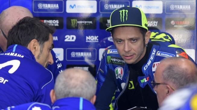 Pebalap Movistar Yamaha, Valentino Rossi (kedua dari kanan), tengah berbicara dengan mekanik timnya saat sesi latihan bebas MotoGP Valencia di Sirkuit Ricardo Tormo, Valencia, Sabtu (17/11/2018). [AFP/Jose Jordan]