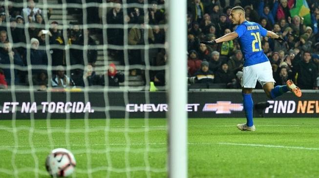 Striker Brasil Richarlison merayakan golnya ke gawang Kamerun dalam laga persahabatan di Stadium MK, Inggris. Glyn KIRK / AFP