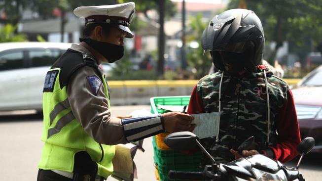 Petugas gabungan dari Badan Pajak dan Retribusi Daerah, Polisi Satuan Lalu Lintas Polda Metro, serta Jasa Raharja menggelar razia pajak di Jalan Kramat Raya, Jakarta Pusat, Kamis (22/11). [Suara.com/Muhaimin A Untung]
