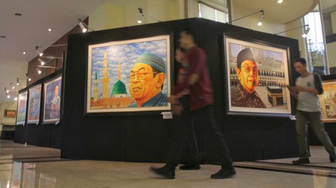 Pengunjung melihat pameran tunggal seni rupa Sang Maha Guru karya pelukis Nabila Dewi Gayatri di Senayan, Jakarta Pusat, Kamis (22/11).(Suara.com/Fakhri Hermansyah)