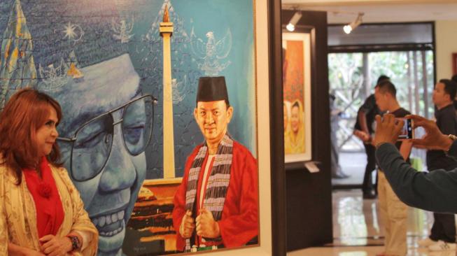 Pengunjung melihat pameran tunggal seni rupa Sang Maha Guru karya pelukis Nabila Dewi Gayatri di Senayan, Jakarta Pusat, Kamis (22/11).(Suara.com/Fakhri Hermansyah)