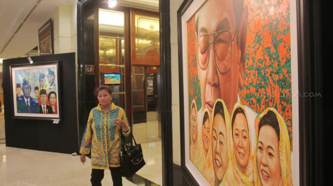 Pengunjung melihat pameran tunggal seni rupa Sang Maha Guru karya pelukis Nabila Dewi Gayatri di Senayan, Jakarta Pusat, Kamis (22/11). (Suara.com/Fakhri Hermansyah)