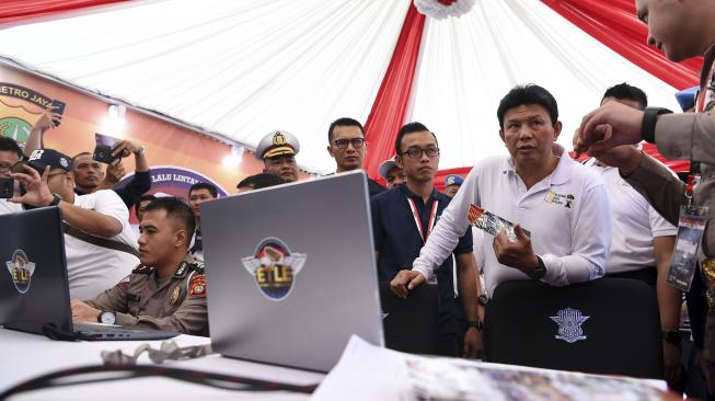 Wakapolri Komjen Pol Ari Dono Sukmanto (kedua kanan) mendapatkan penjelasan dari petugas Ditlantas Polda Metro Jaya mengenai sistem tilang elektronik saat Grand Launching Electronic Traffic Law Enforcement (E-TLE) di kawasan Bundaran HI, Jakarta, Minggu (25/11).  [ANTARA FOTO/Hafidz Mubarak]