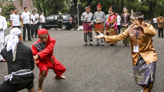 
Presiden Joko Widodo (kedua kiri belakang) didampingi Ibu Negara Iriana Joko Widodo (kedua kanan belakang) didampingi Gubernur Sumatera Selatan Herman Deru (kiri belakang) dan istri Febrita Lustia (kanan belakang) menyaksikan atraksi pencak silat saat menghadiri penganugerahan gelar kehormatan adat Komering Provinsi Sumatera Selatan di halaman Griya Agung Palembang, Sumatera Selatan, Minggu (25/11).  [ANTARA FOTO/Nova Wahyudi]