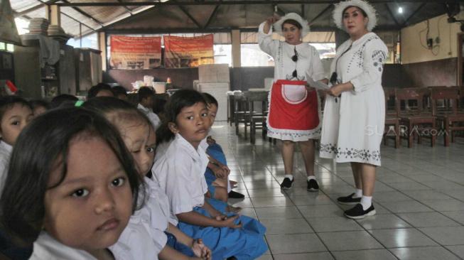 Ibu guru kembar Rian dan Rossi saat mengajar di Sekolah  Kartini Kampung Lodan, Jakarta Utara, Senin (26/11). (Suara.com/Fakhri Hermansyah)