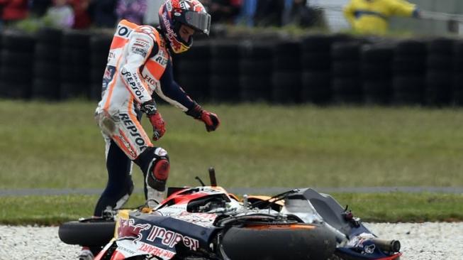 Pebalap Repsol Honda, Marc Marquez, melihat ke arah motor Honda RC213V-nya yang rusak setelah dirinya terjatuh pada balapan MotoGP Australia 2016. [AFP/Jeremy Brown]