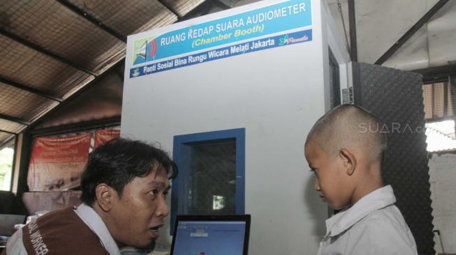 Siswa Sekolah saat diperiksa menggunakan mesin Chamber Booth (Ruang Kedap Suara Audiometer) di Pademangan Jakarta Utara, Senin (26/11). (Suara.com/Fakhri Hermansyah)